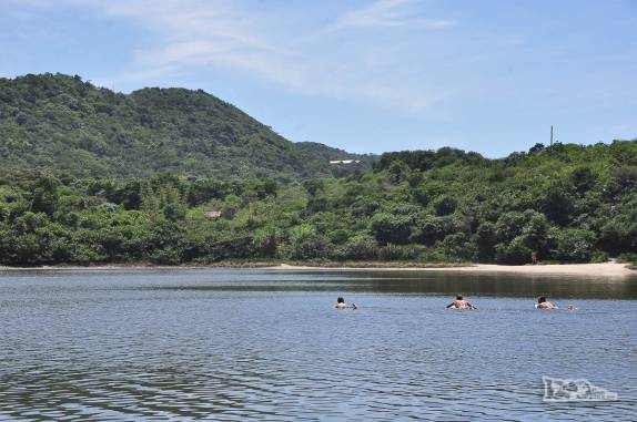 Surfistas voltam remando para casa na Lagoa do Meio, na Praia do Rosa, Imbituba, litoral sul de Santa Catarina